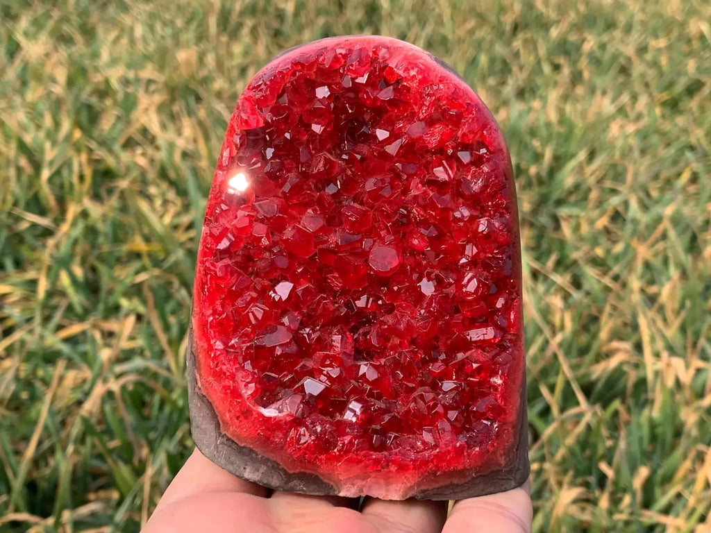 red quartz geode druzy crystal cluster held in hand outdoor
