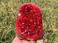 red quartz geode druzy crystal cluster held in hand outdoor